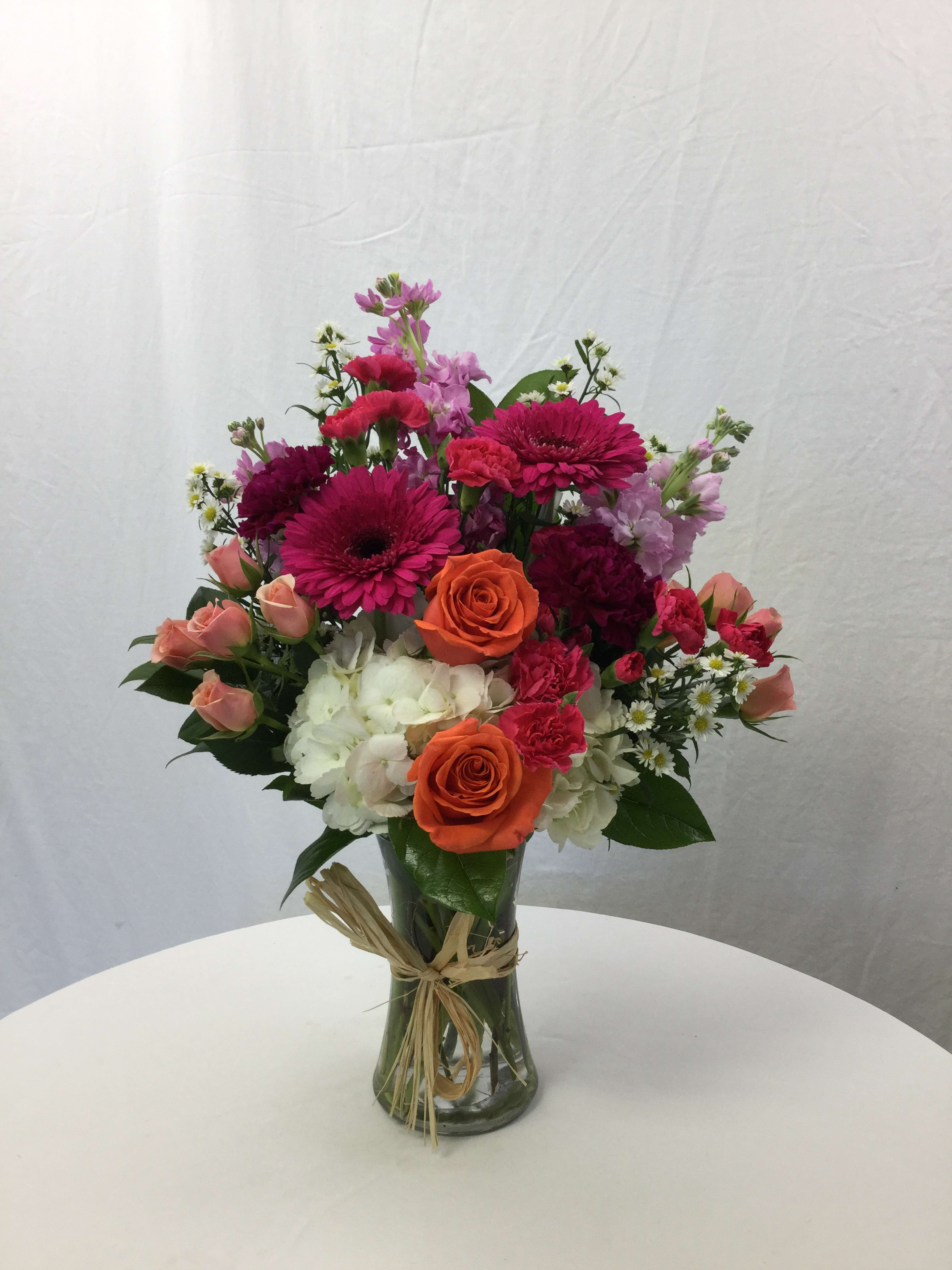 Friendship of Love Bouquet - This beautiful bouquet makes for a wonderful gift for any special occasion. Handcrafted and designed in a clear glass vase, fresh blooms, and fresh greens.
