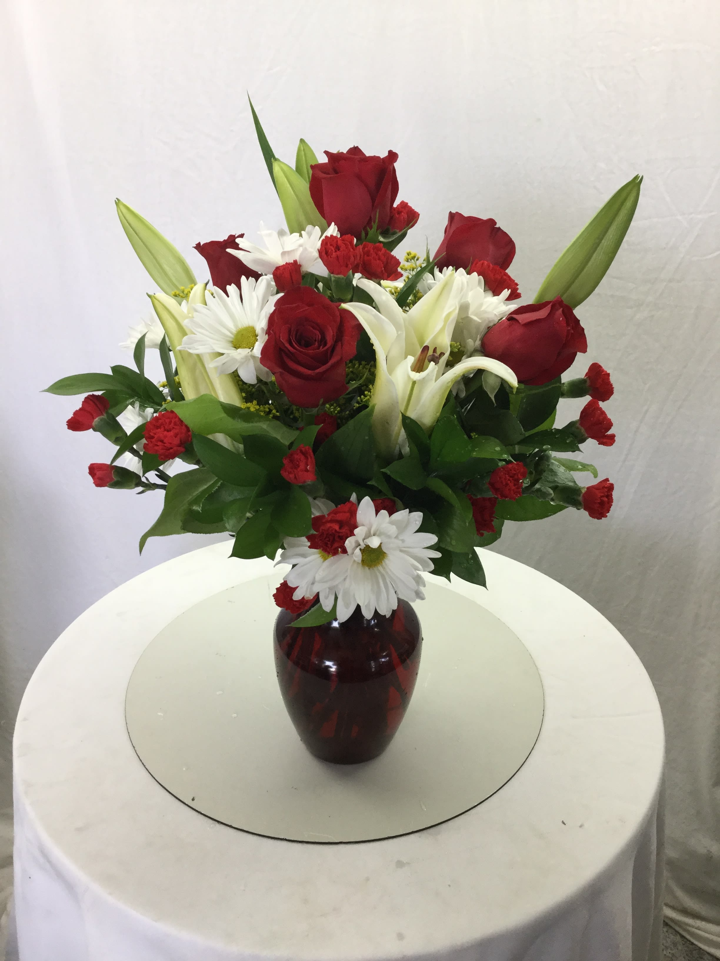 Romantic Love Bouquet - This beautiful bouquet makes for a wonderful gift for the one you love. Full of fresh blooms in shades of red and white, handcrafted and designed in a red vase. Due to possible manufacturing delays, red vase may need to be substituted with a clear glass vase topped off with a red bow.