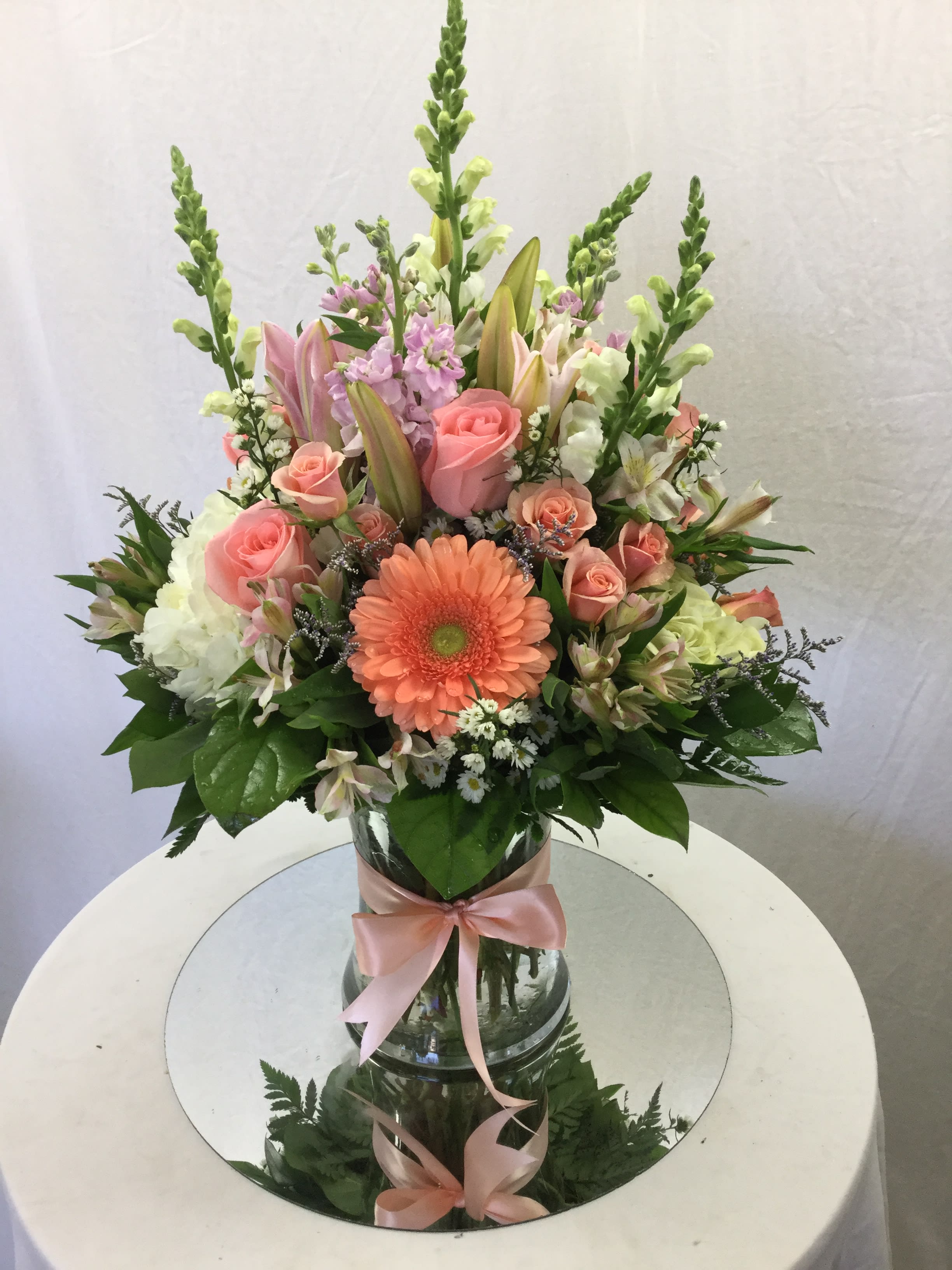 Exquisite Hug Bouquet - This stunning bouquet is a perfect gift for every special occasion. Includes a wide array of mixed fresh blooms, fresh greens, a beautiful bow and handcrafted and designed in a clear glass vase.