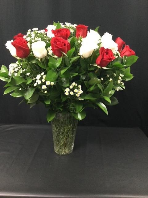 Red and white roses arranged in a clear glass vase