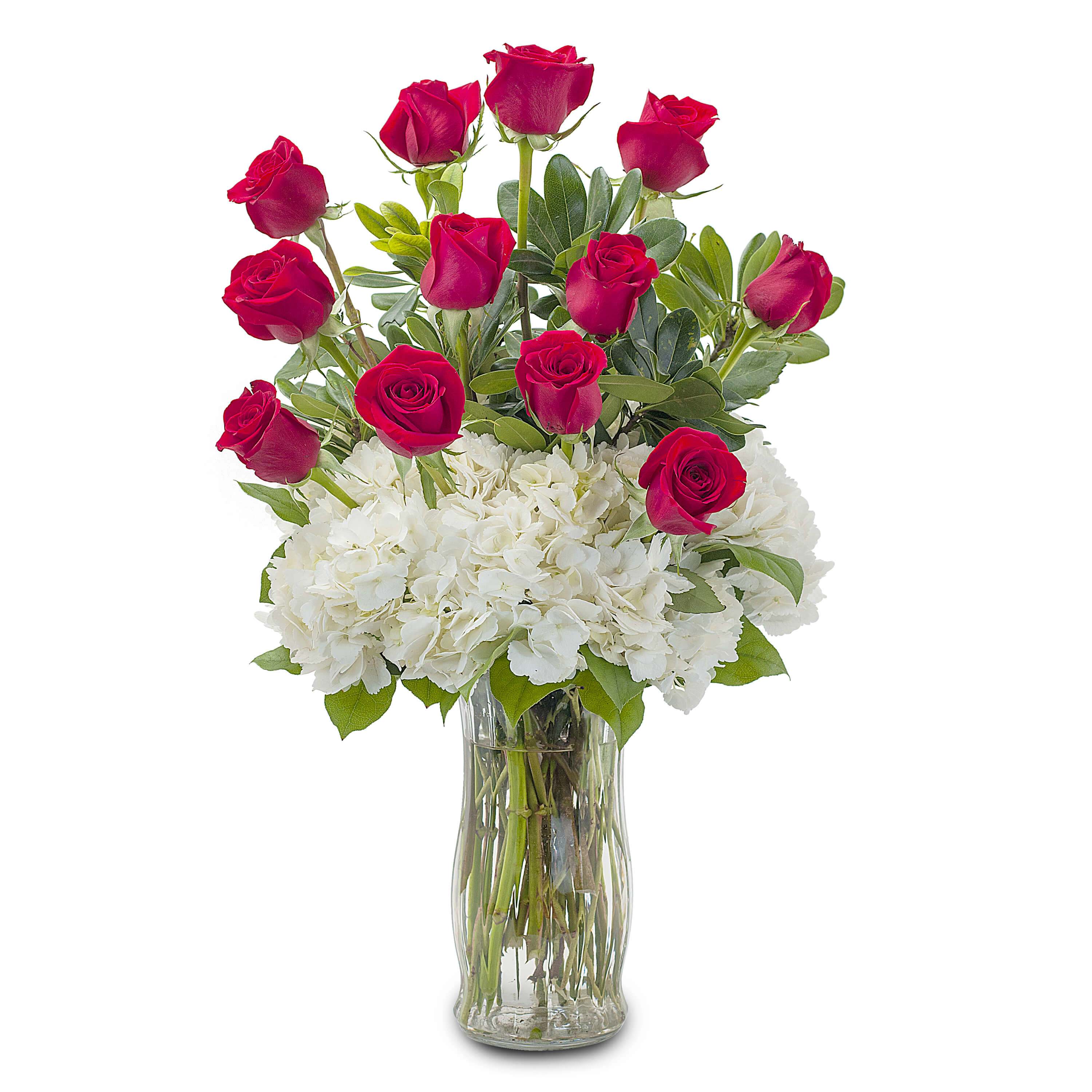 Red roses arranged with white hydrangeas in a clear glass vase