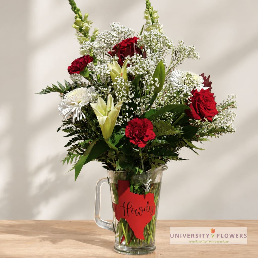 Red and white mixed bouquet in a glass pitcher vase