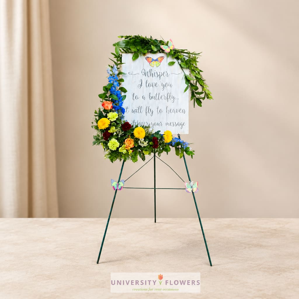 Floral standing easel with a butterfly-themed sympathy sign and colorful flowers