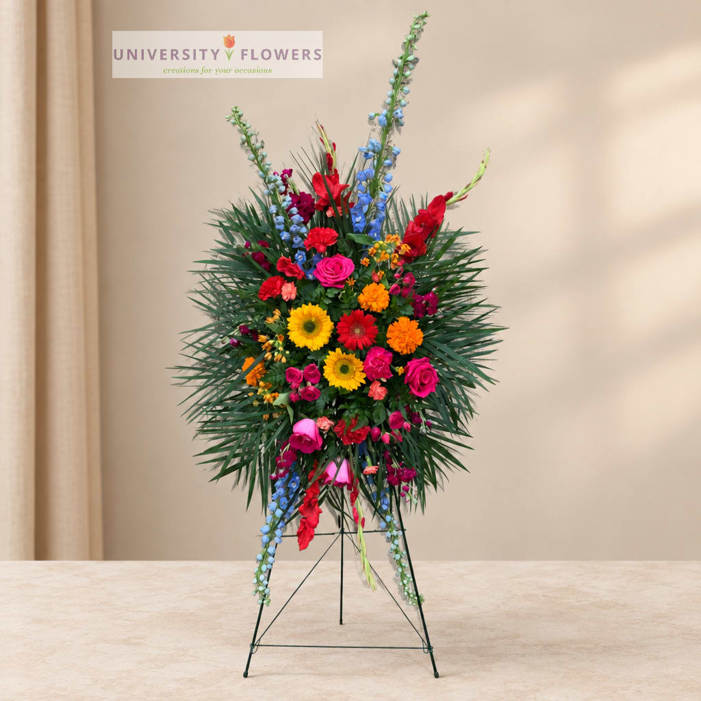 Tall standing floral spray with bright mixed blooms on an easel