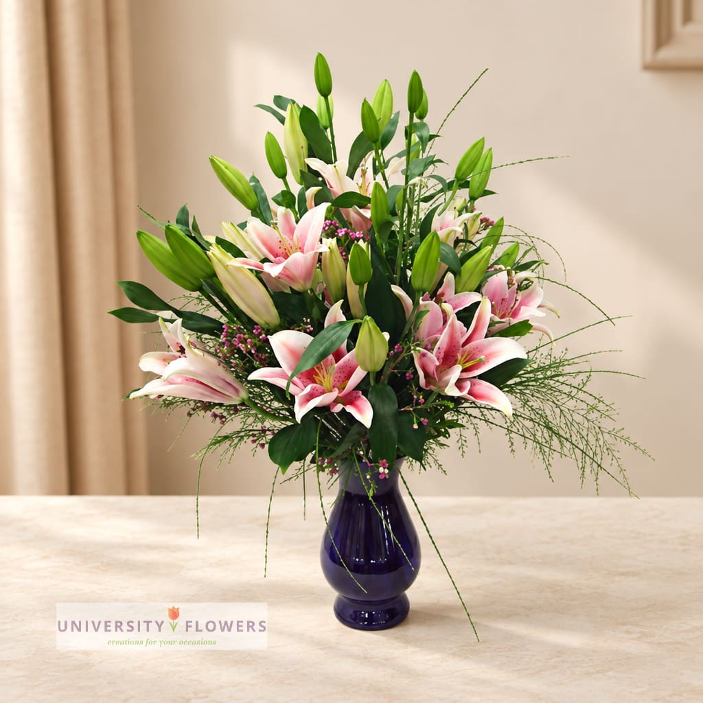 Pink and white lilies in a dark glass vase