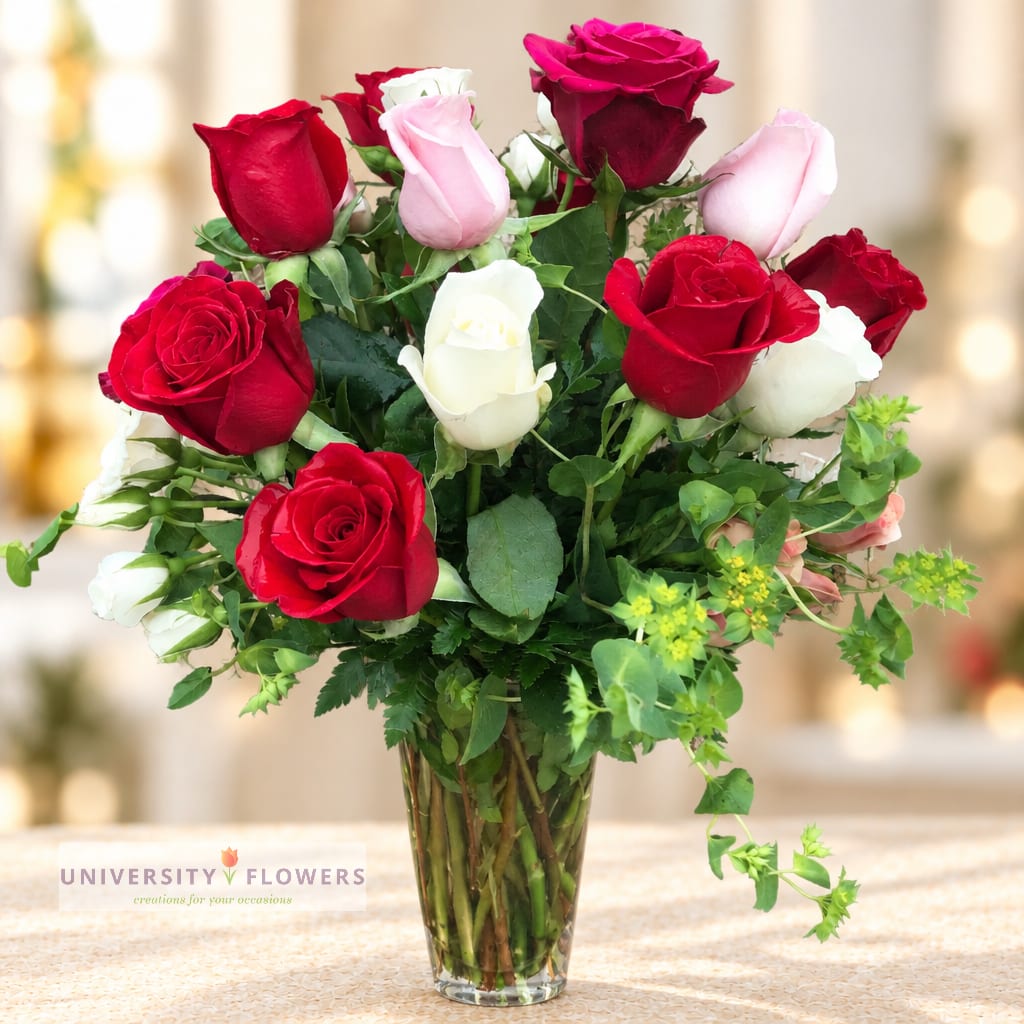Bouquet of red, pink, and white roses in a clear glass vase