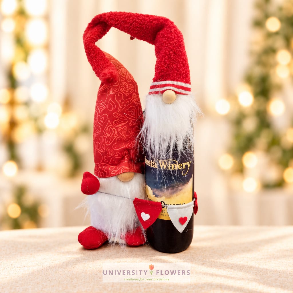 Two festive gnome bottle toppers with red hats and white beards on a wine bottle