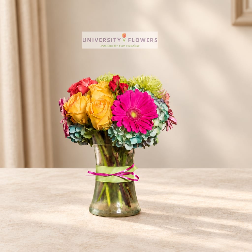 Colorful bouquet of roses and gerbera daisies in a glass vase
