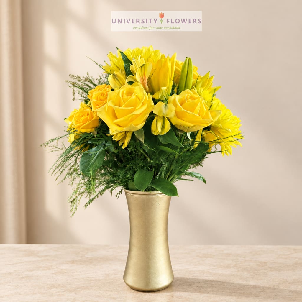 Yellow roses and lilies in a gold vase