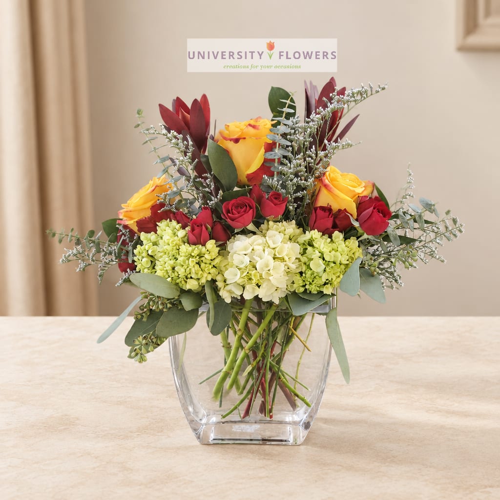 Bouquet of red and yellow roses in a clear glass vase