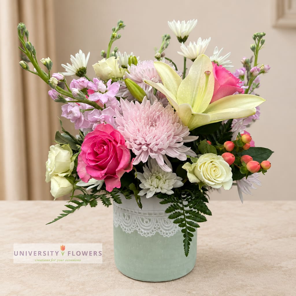 Mixed bouquet in a mint vase with pink, white, and yellow blooms