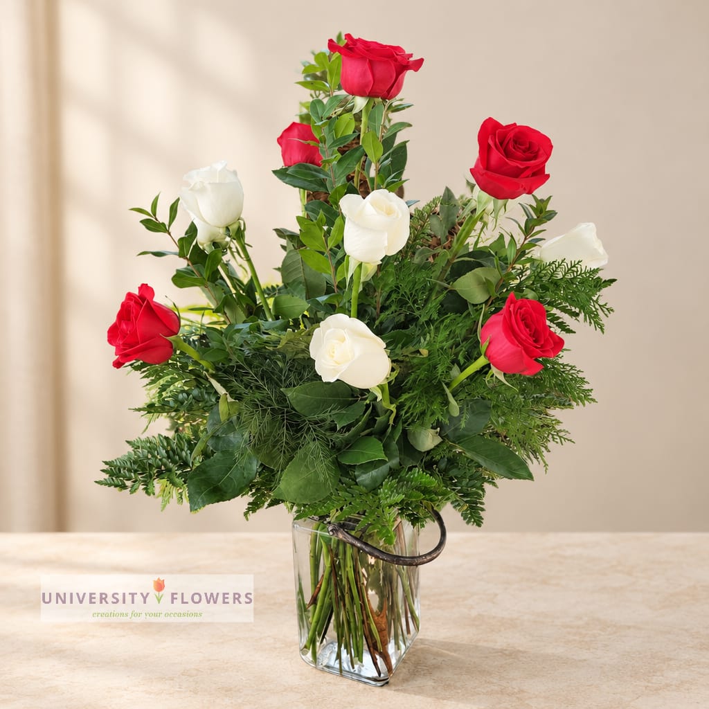 Red and white roses arranged in a clear glass vase