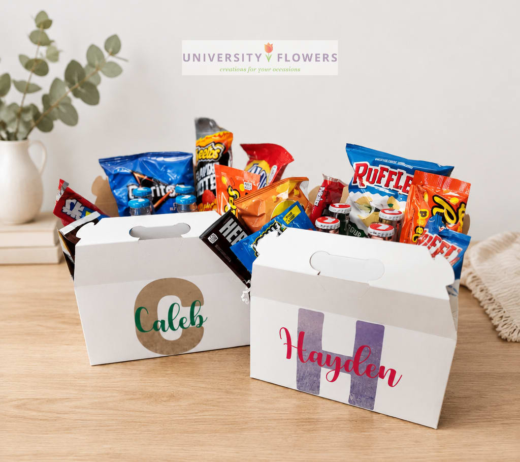 Two personalized snack gift boxes filled with candy and chips on a table