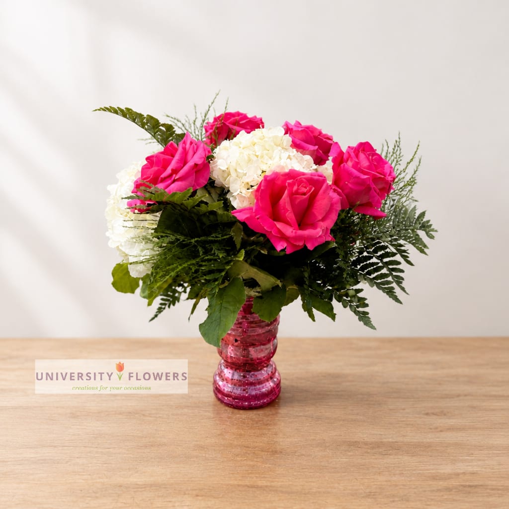 Pink roses and white hydrangeas in a pink glass vase