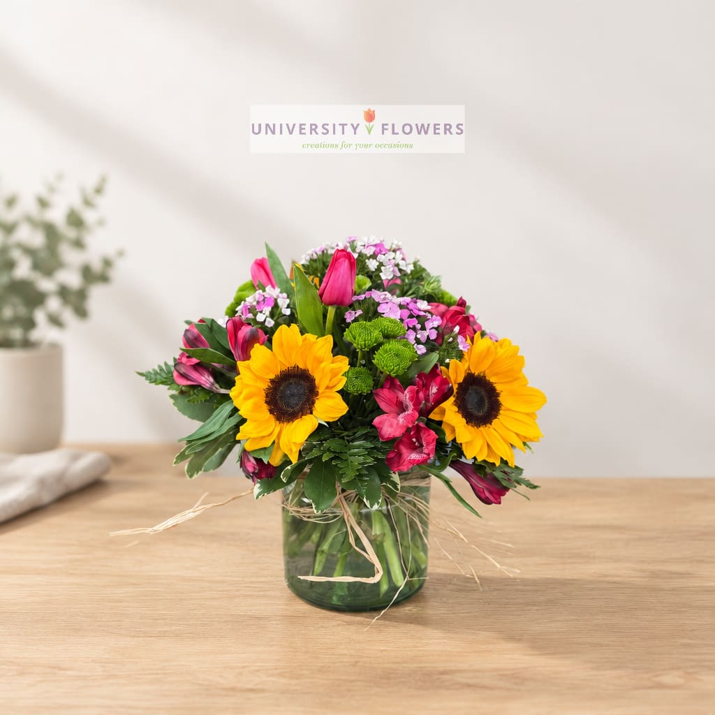 Mixed bouquet with sunflowers and pink alstroemeria in a glass vase