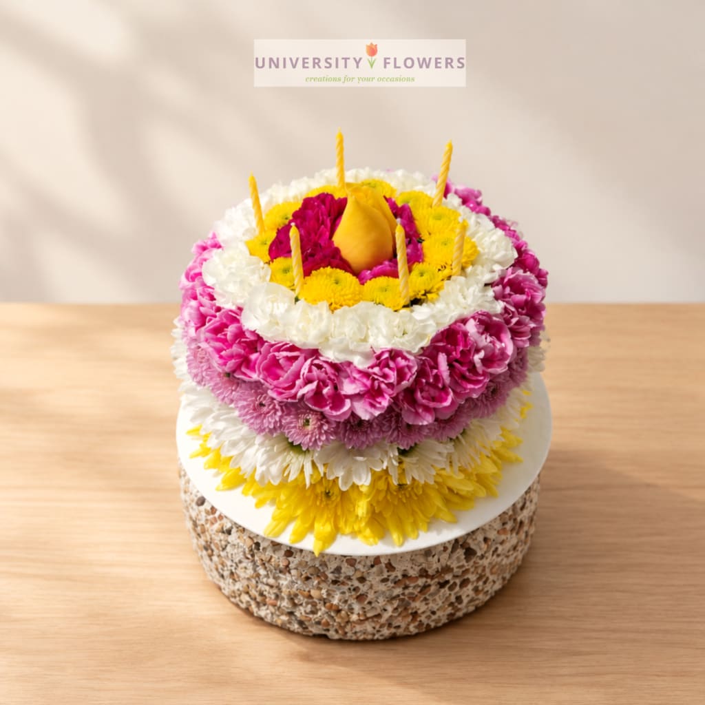 Round floral cake with candles and a pear-shaped topper