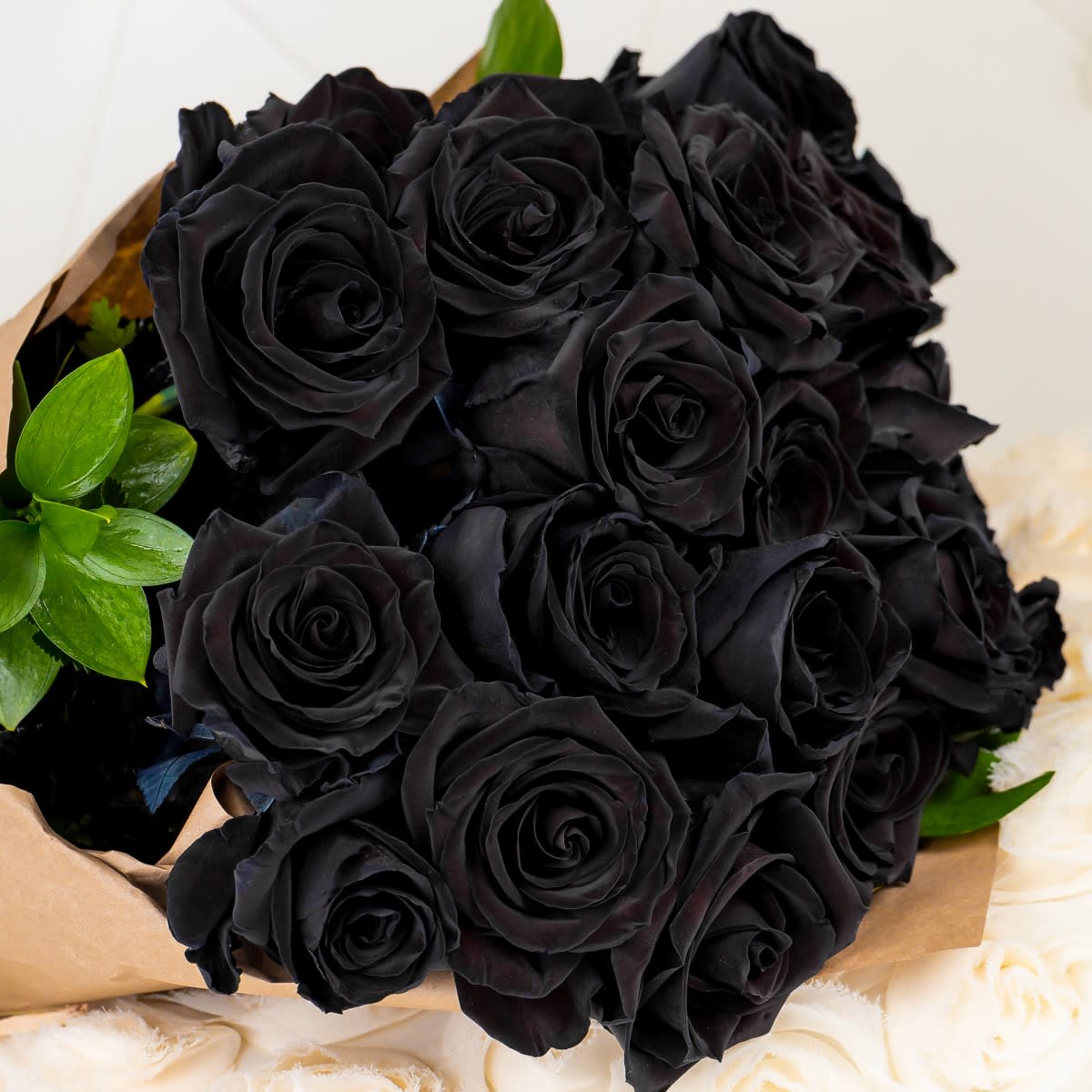 Bouquet of black roses with a few green leaves