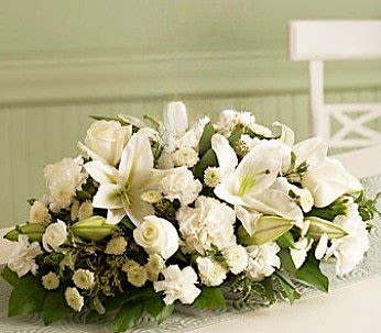 Formal Dinner Centerpiece - They expect the flowers so why not send them a memory?   Our oblong centerpieces come with a lush assortment of white flowers and holiday greenery.   Please be sure to let us know is the "Special Instructions" section of your order if you do or do not want candles.