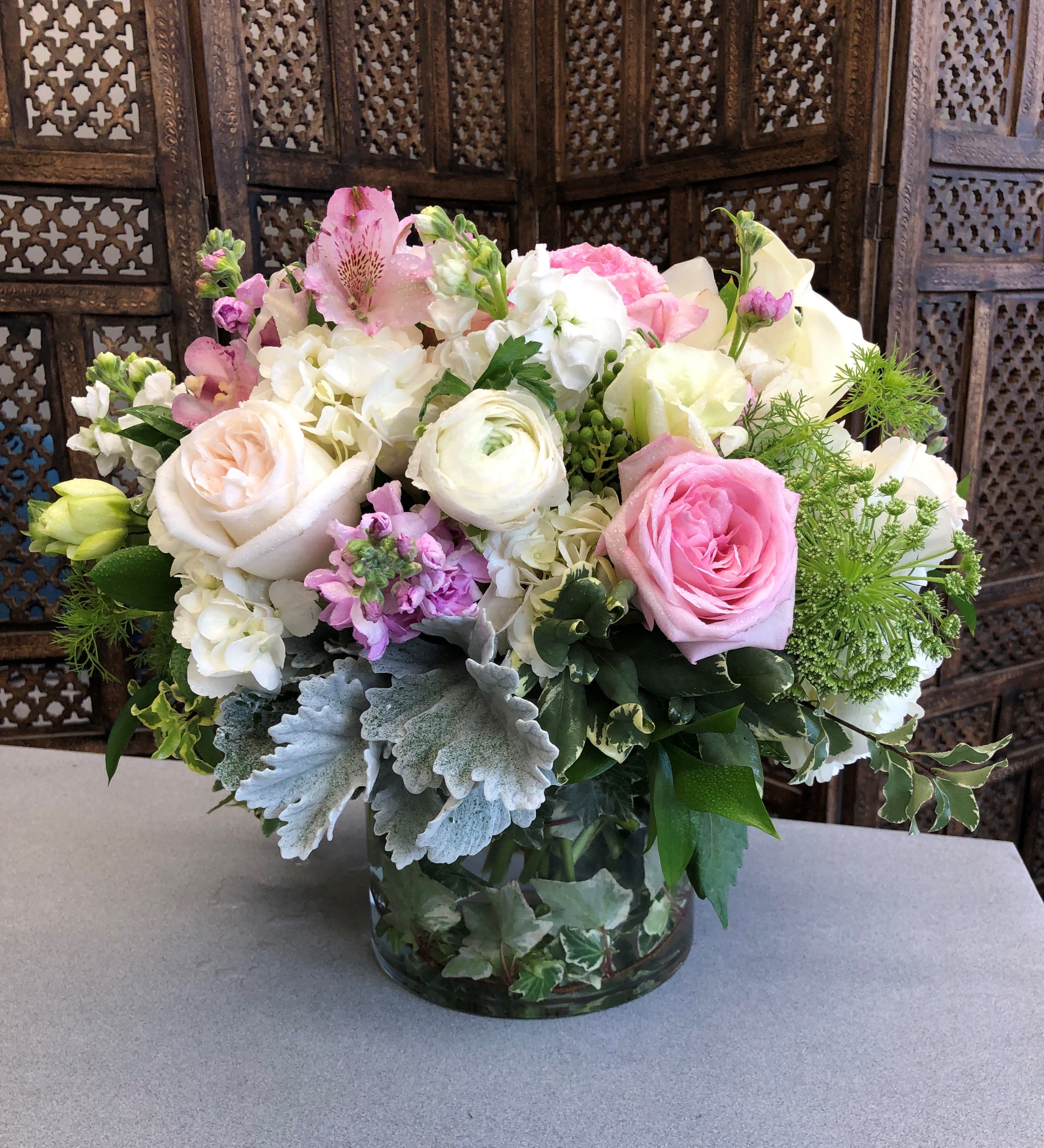 Pink and white mixed flower arrangement in a glass vase