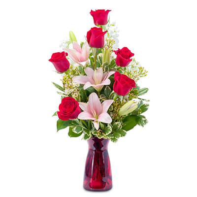 Red roses and pink lilies in a red glass vase