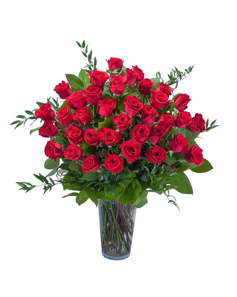 Red roses arranged in a clear glass vase