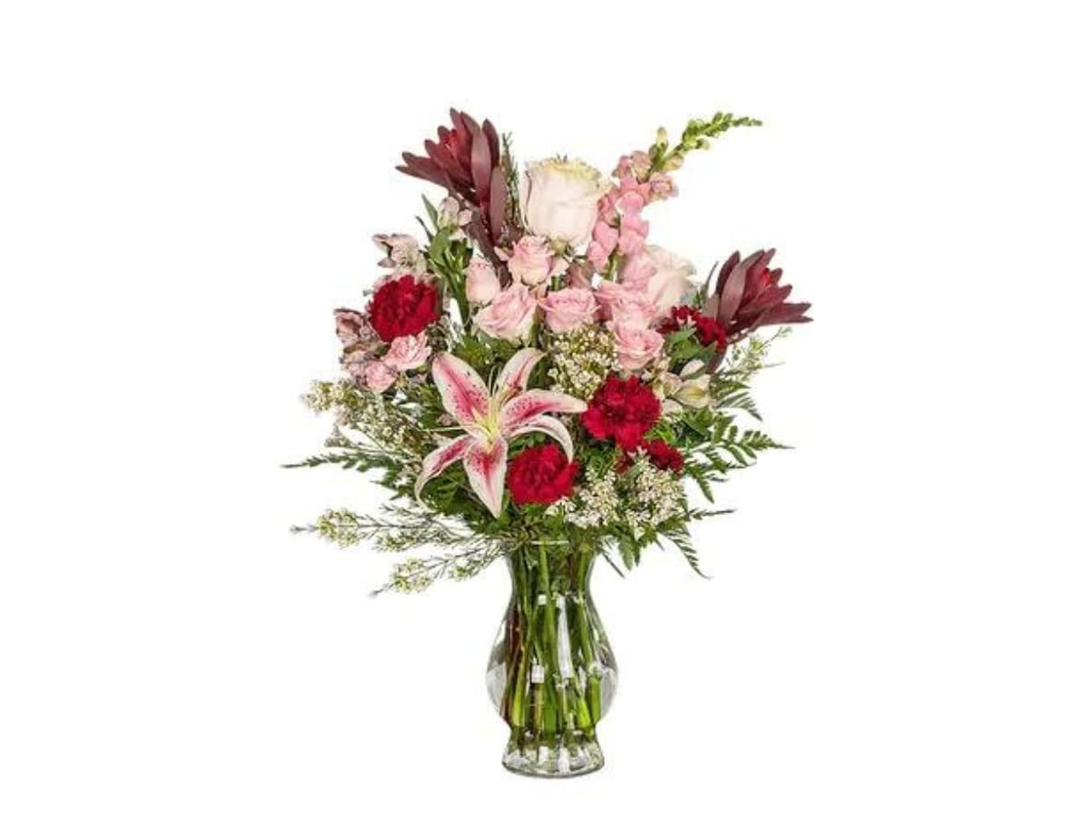 Mixed pink and red bouquet in a clear glass vase