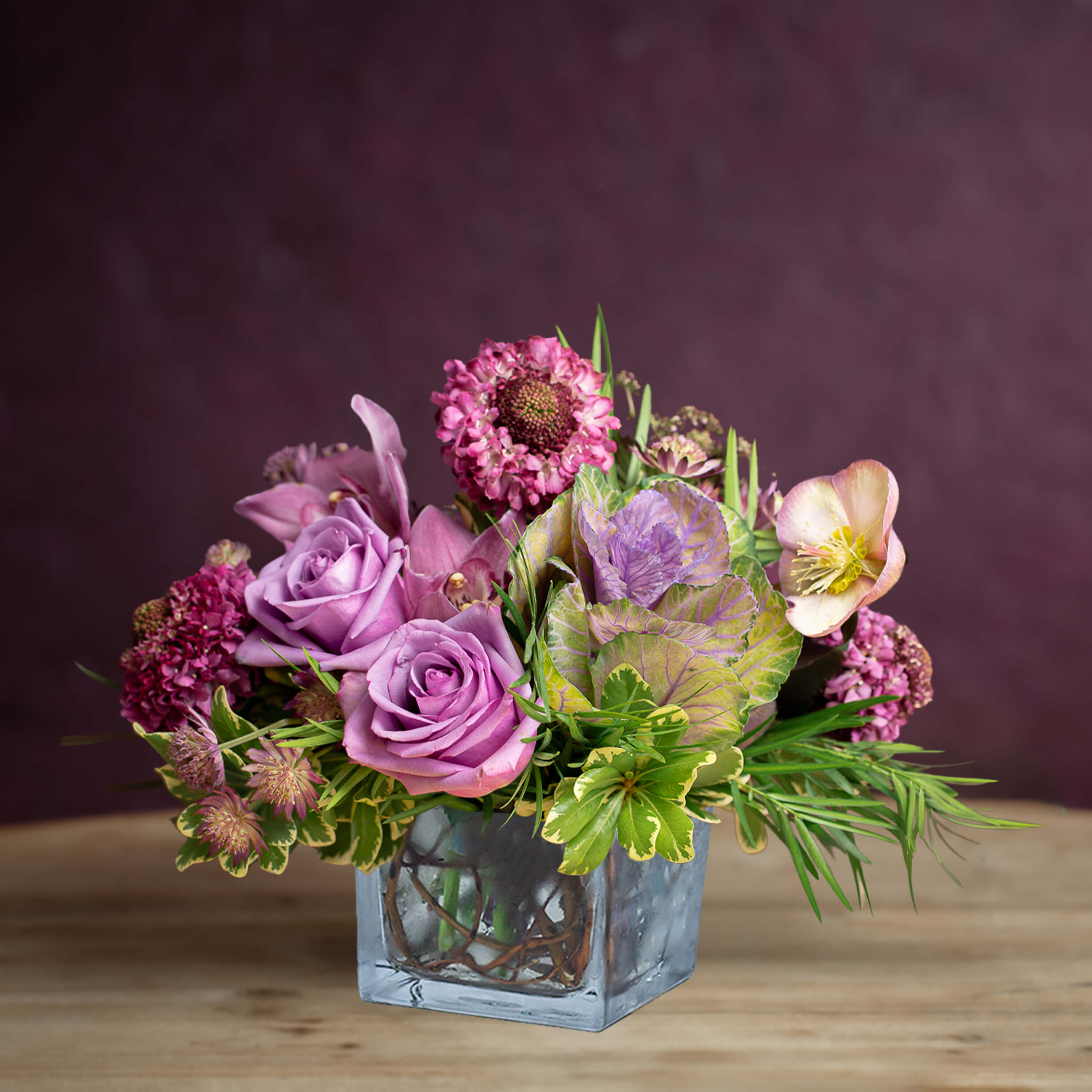 Lavender roses and mixed blooms in a square glass vase