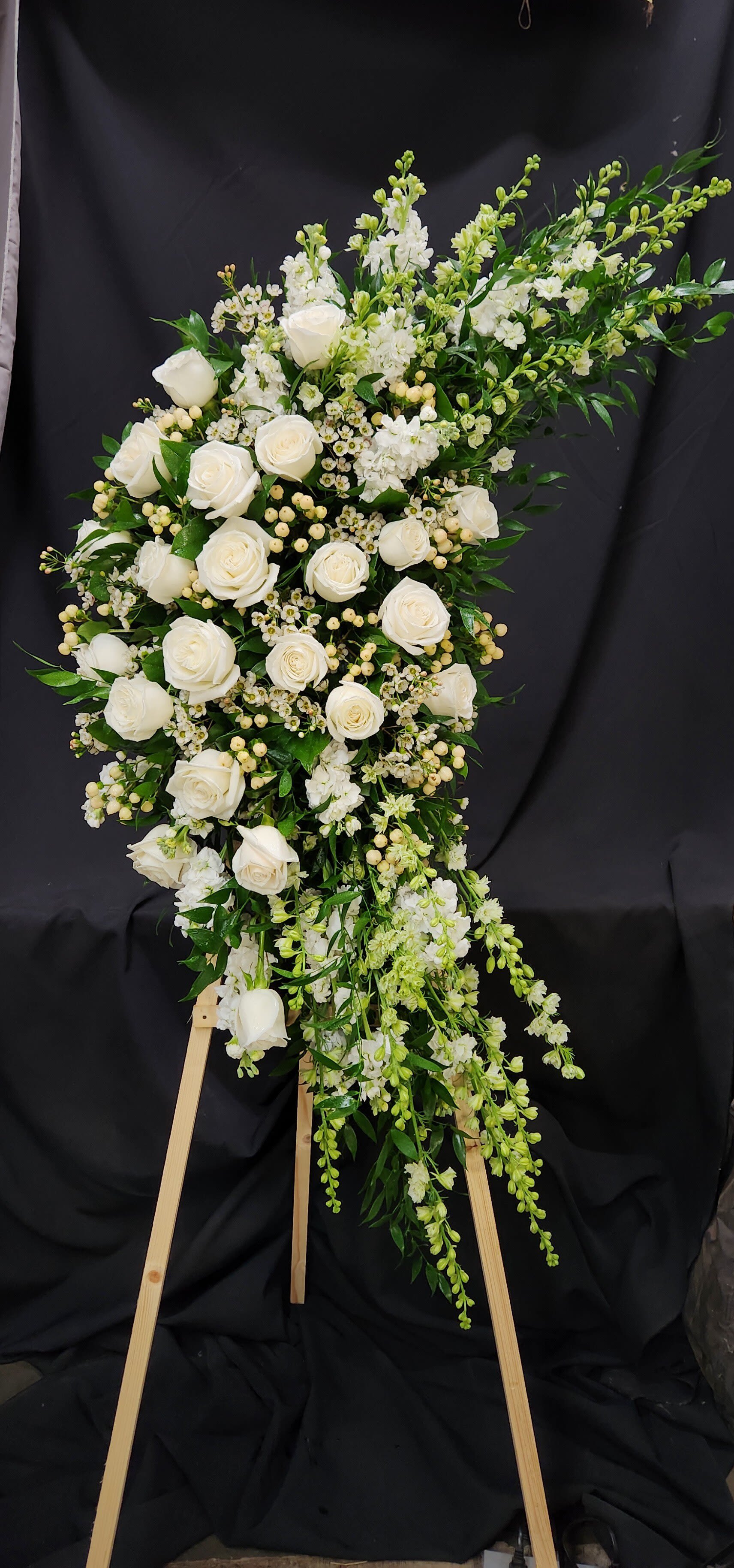White rose standing spray on a wooden easel