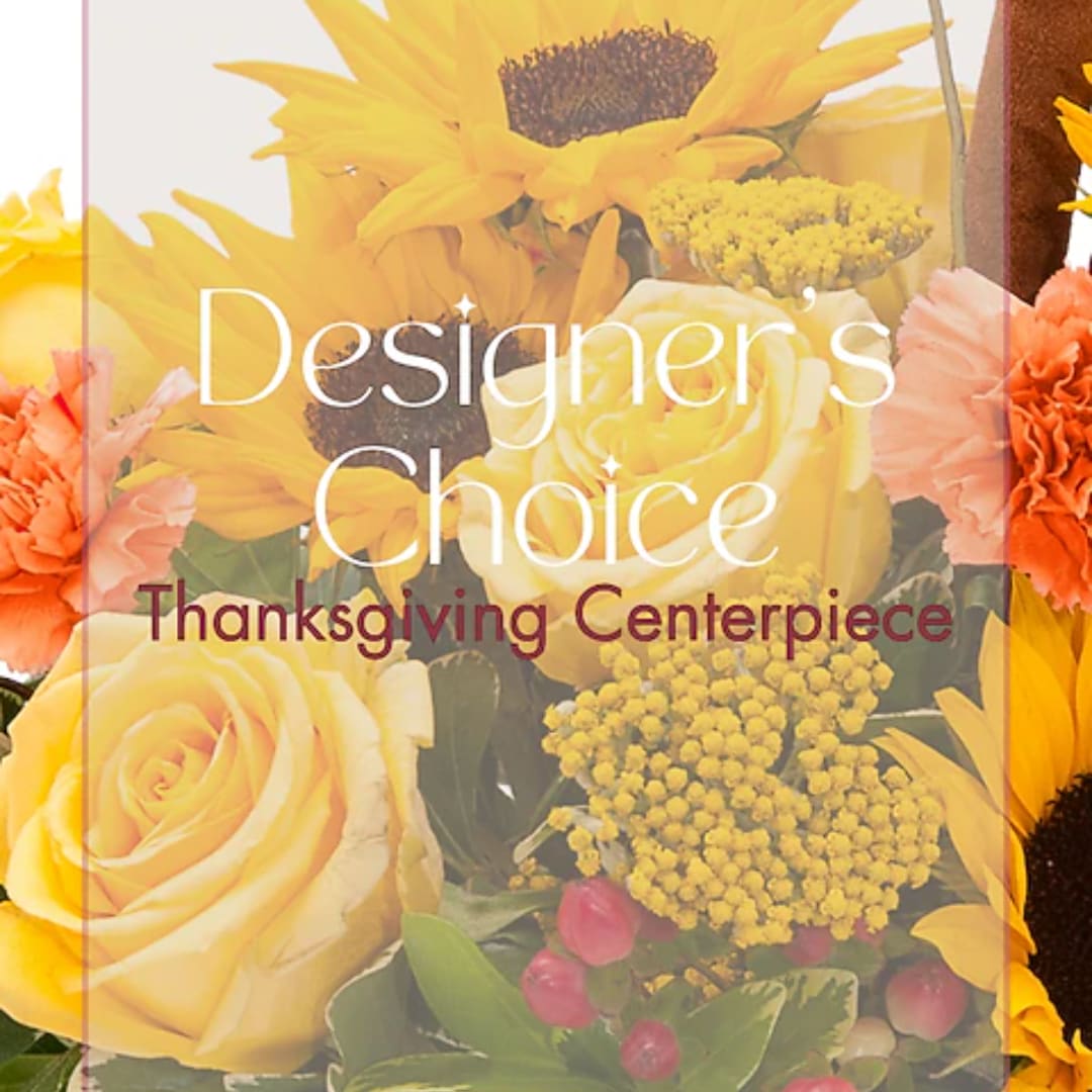 Yellow roses and sunflowers with orange carnations in a centerpiece.