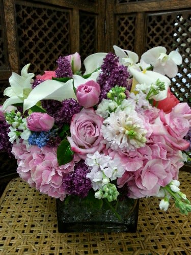 Pink and white floral arrangement in a square glass vase