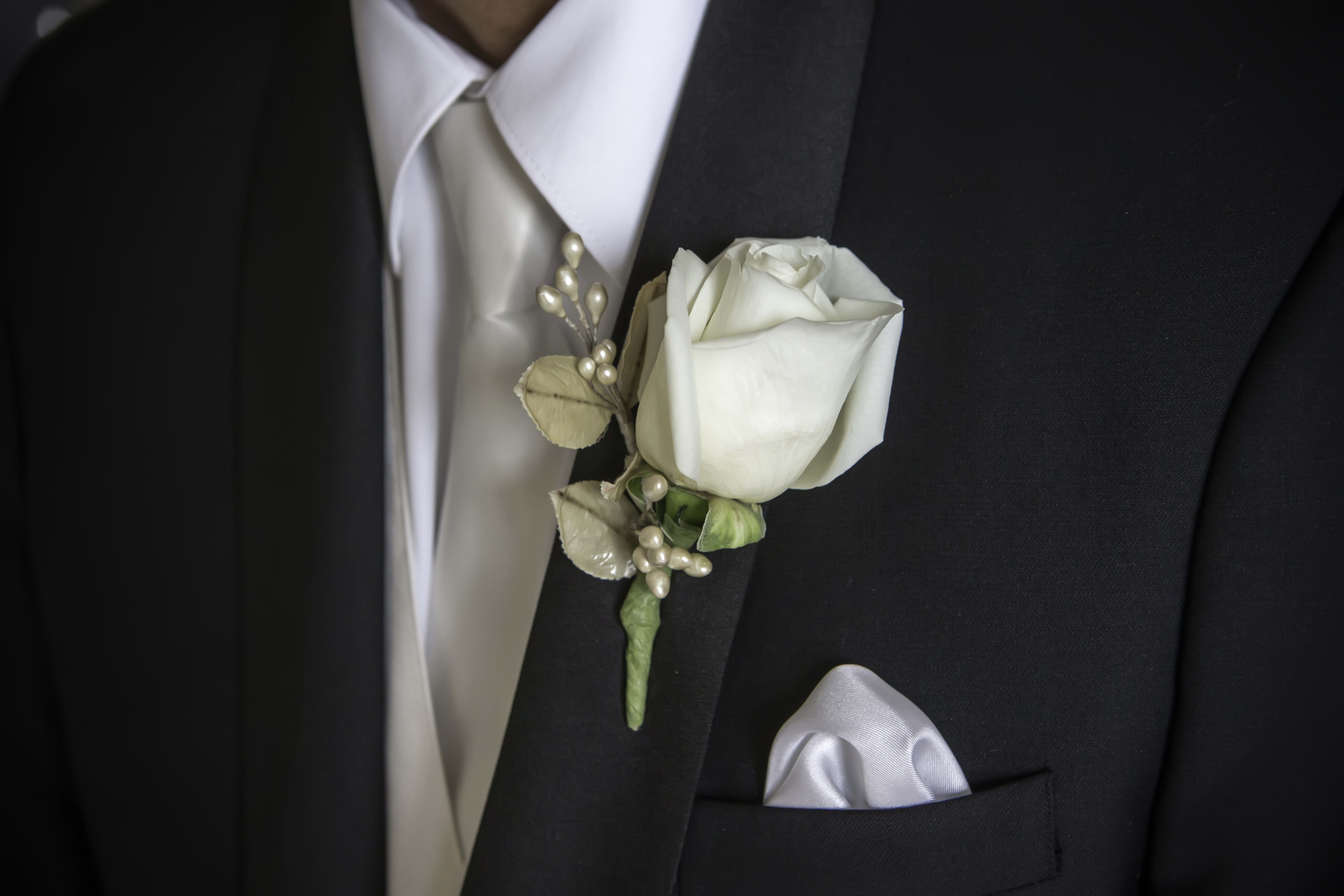 White rose boutonniere on a black suit jacket