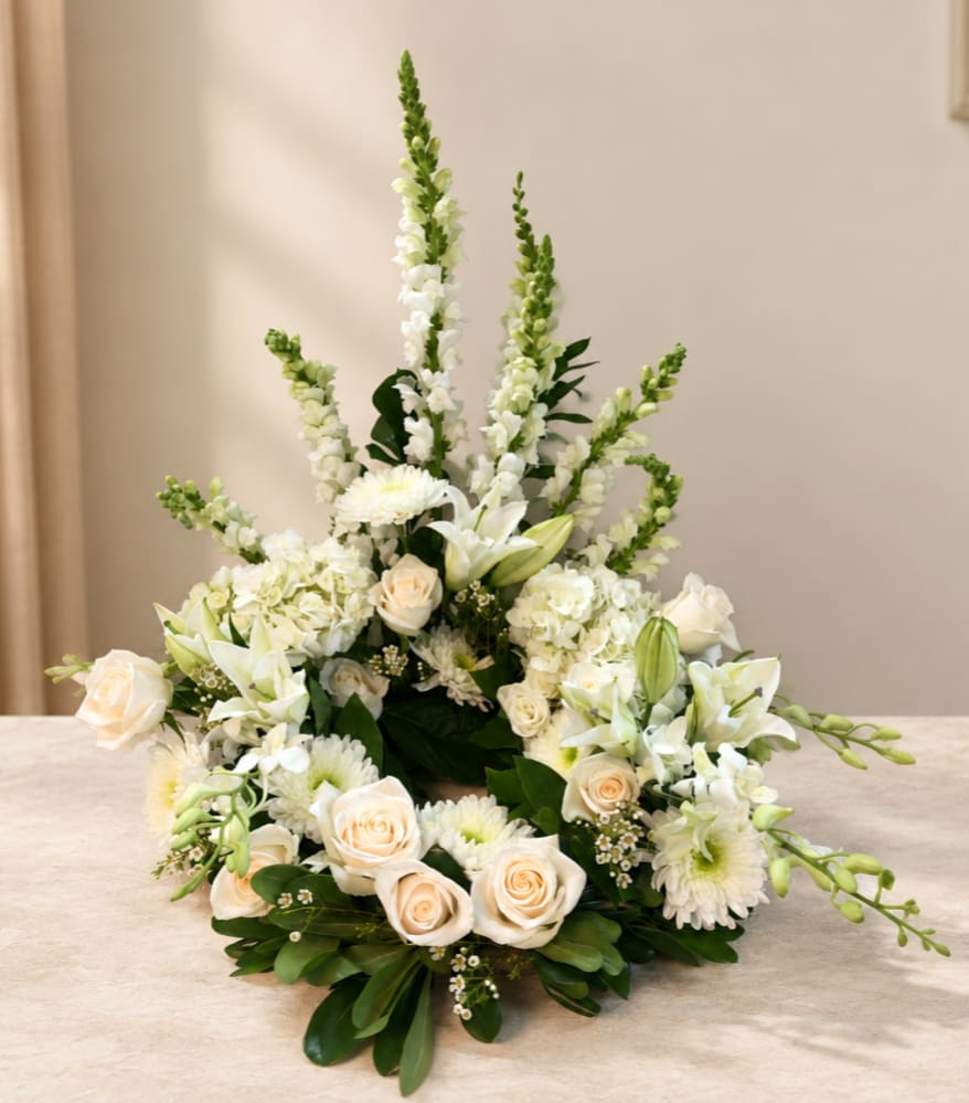 White floral arrangement with roses, lilies, and tall snapdragons