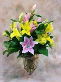 Bouquet of pink and yellow lilies in a glass vase