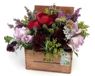 Mixed roses and filler flowers arranged in a wooden box