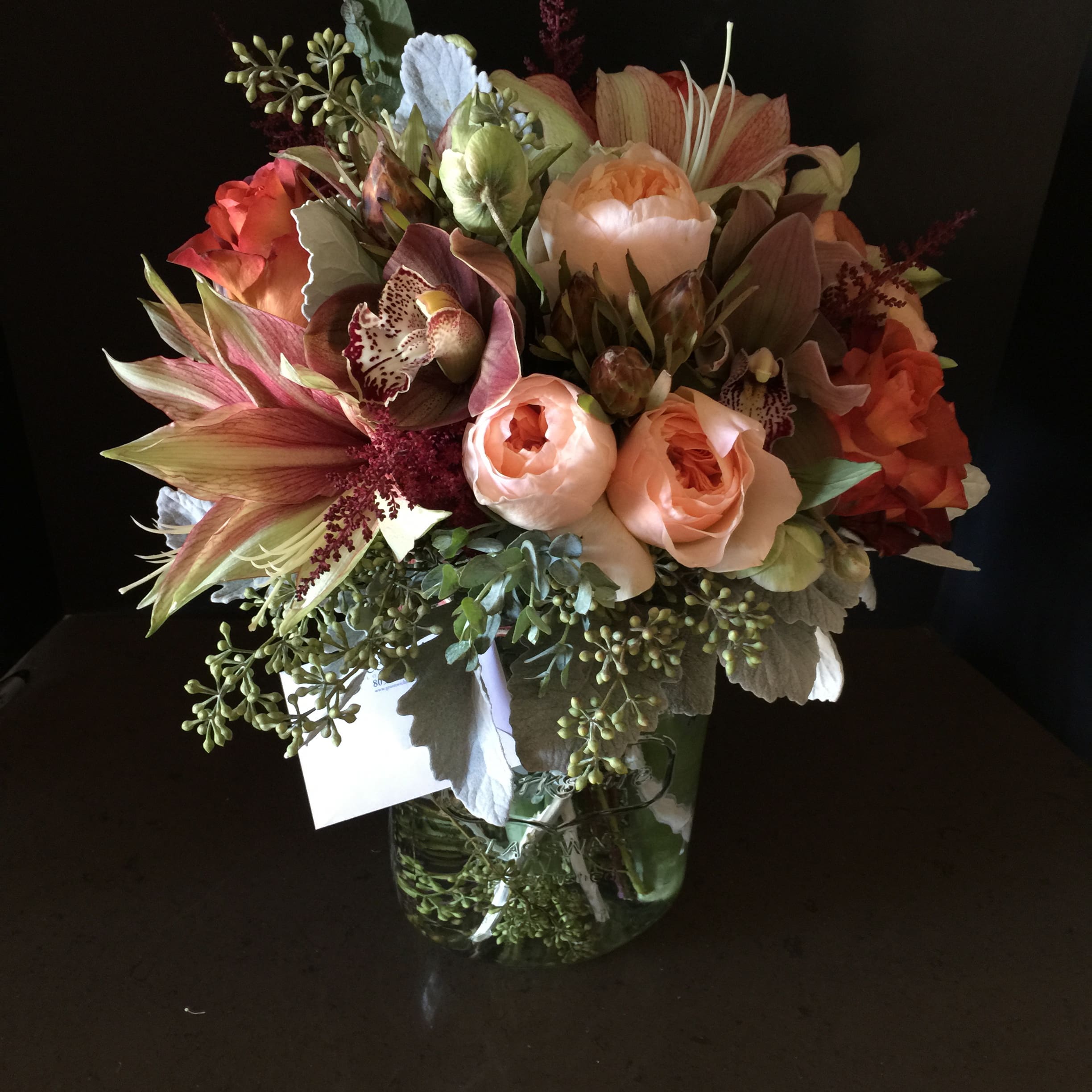 Bouquet of peach and coral flowers in a glass vase