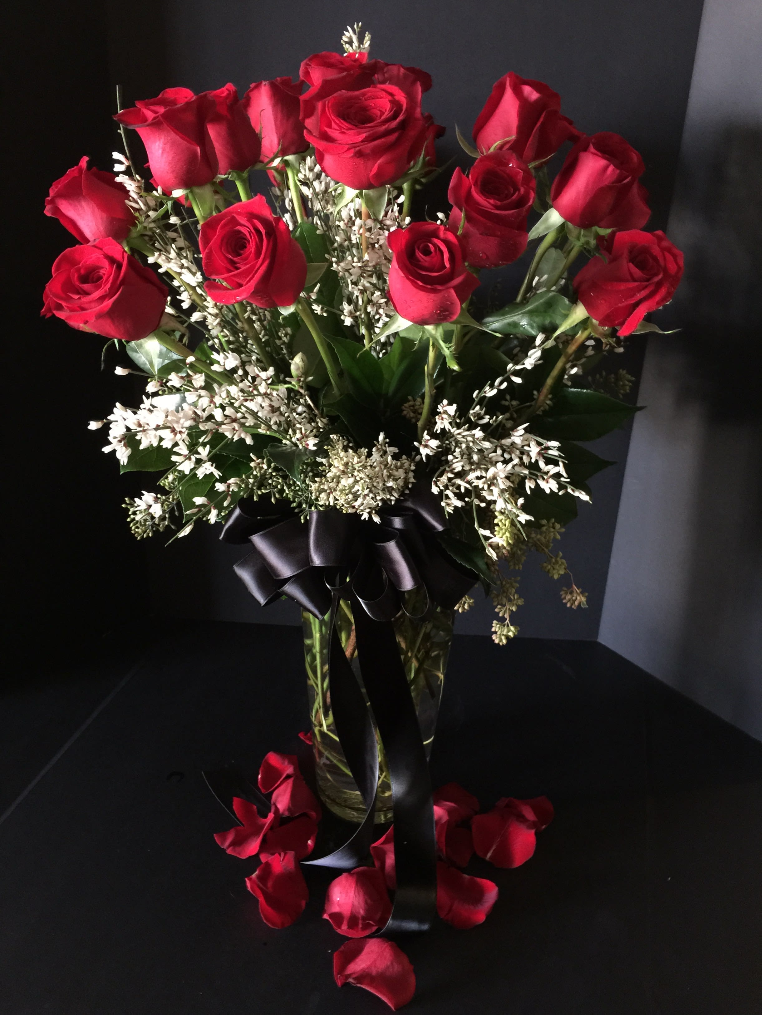 Bouquet of red roses in a glass vase with a black ribbon