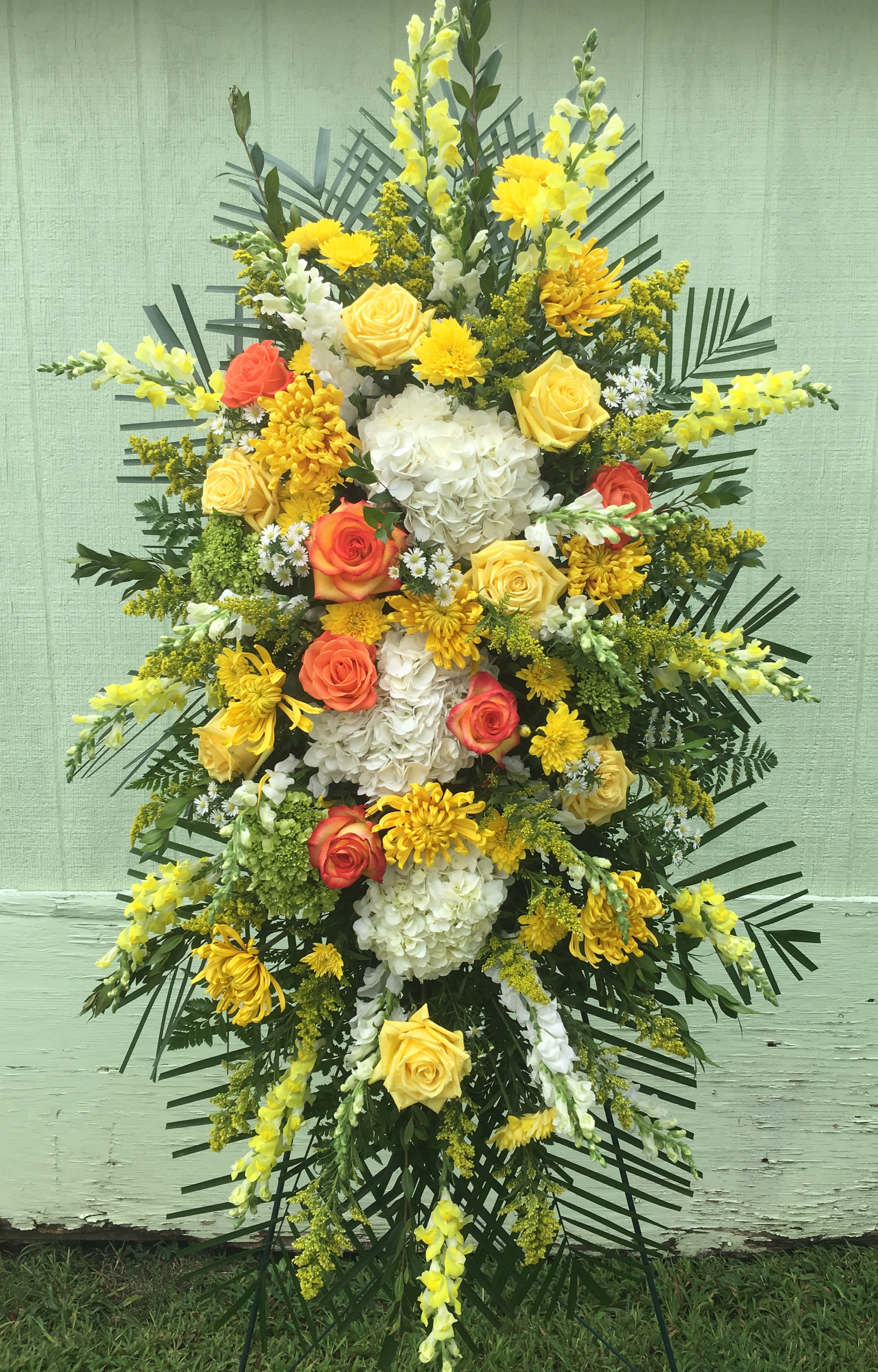 Standing floral spray with yellow, white, and orange blooms