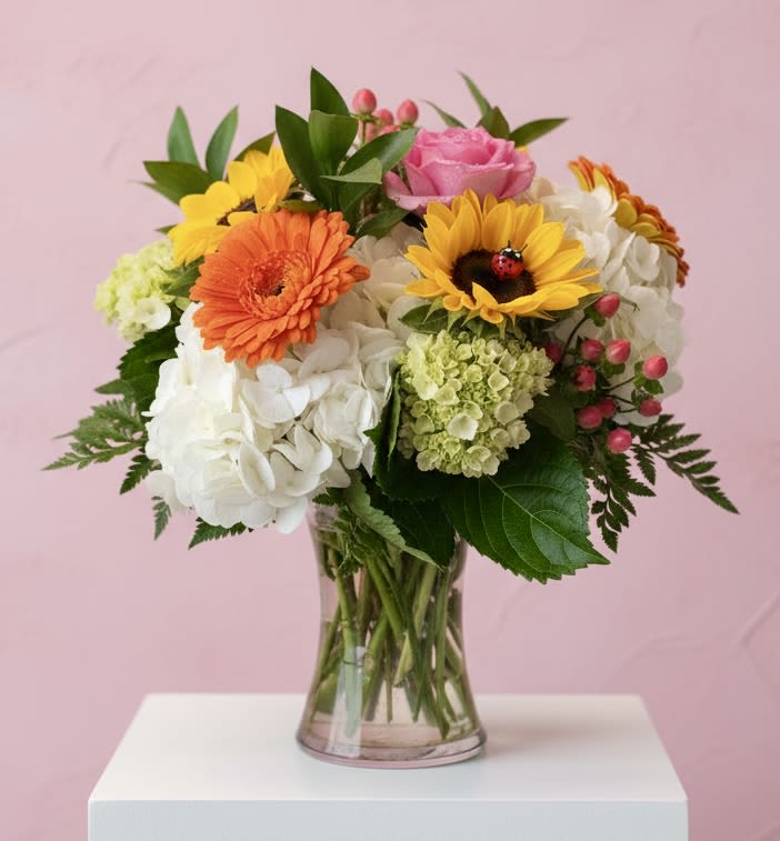 Happiness In a Vase - White hydrangeas, mini green hydrangea, sunflowers (with an adorable ladybug), roses, gerber all arranged beautifully in a clear glass vase