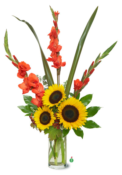 Tall arrangement of yellow sunflowers and orange flowers in a clear glass vase.