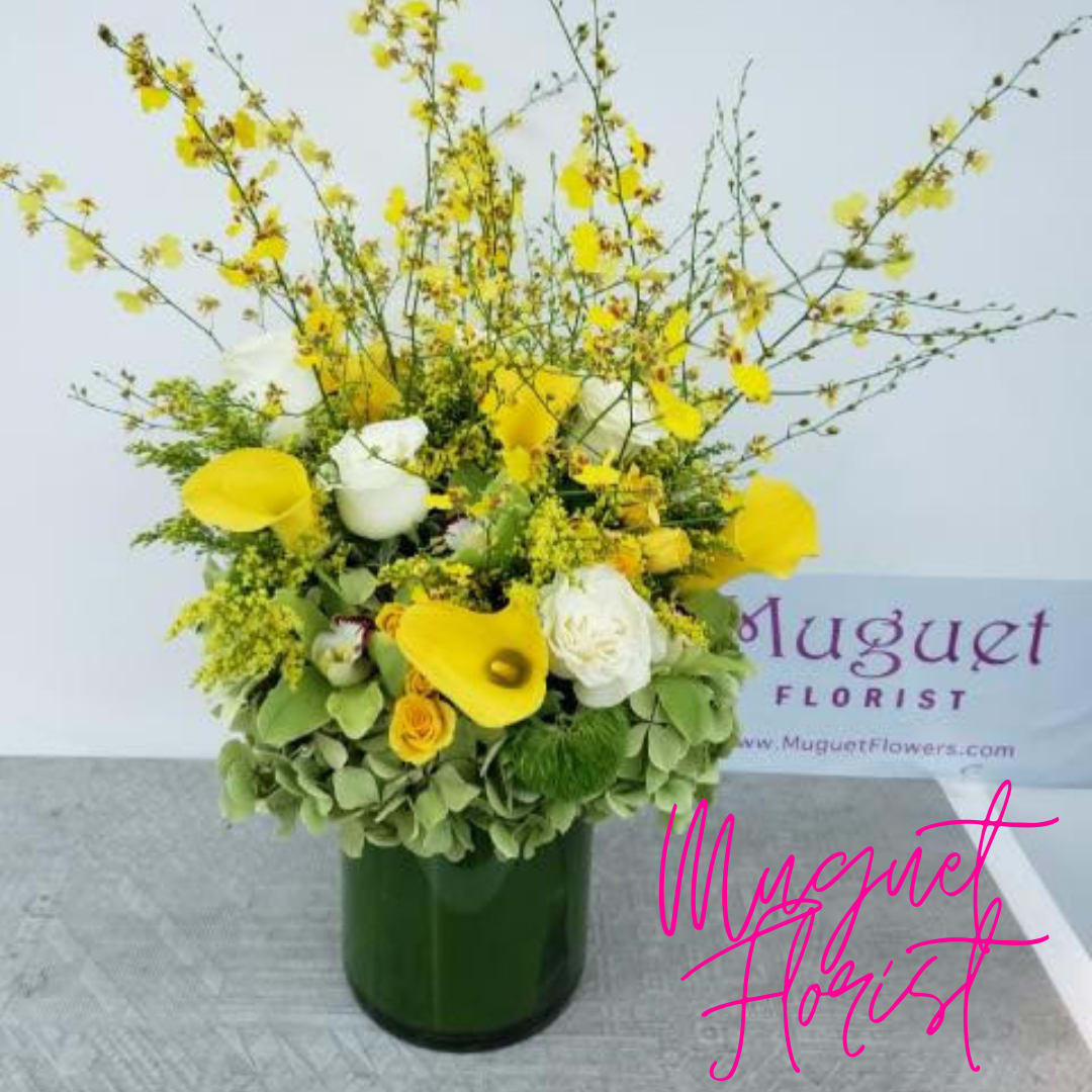 Yellow and white floral arrangement in a green vase