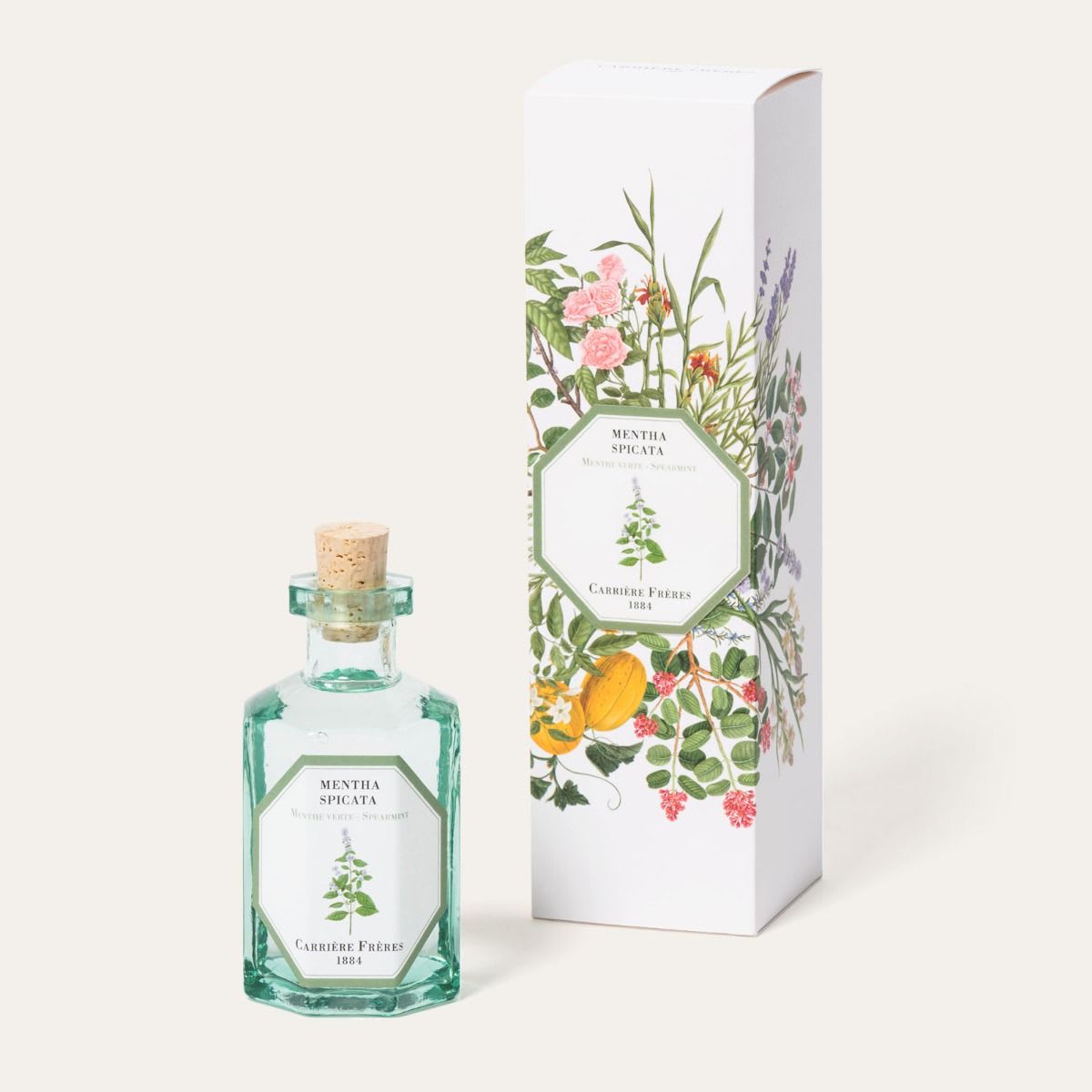 Green glass perfume bottle with matching floral-patterned box
