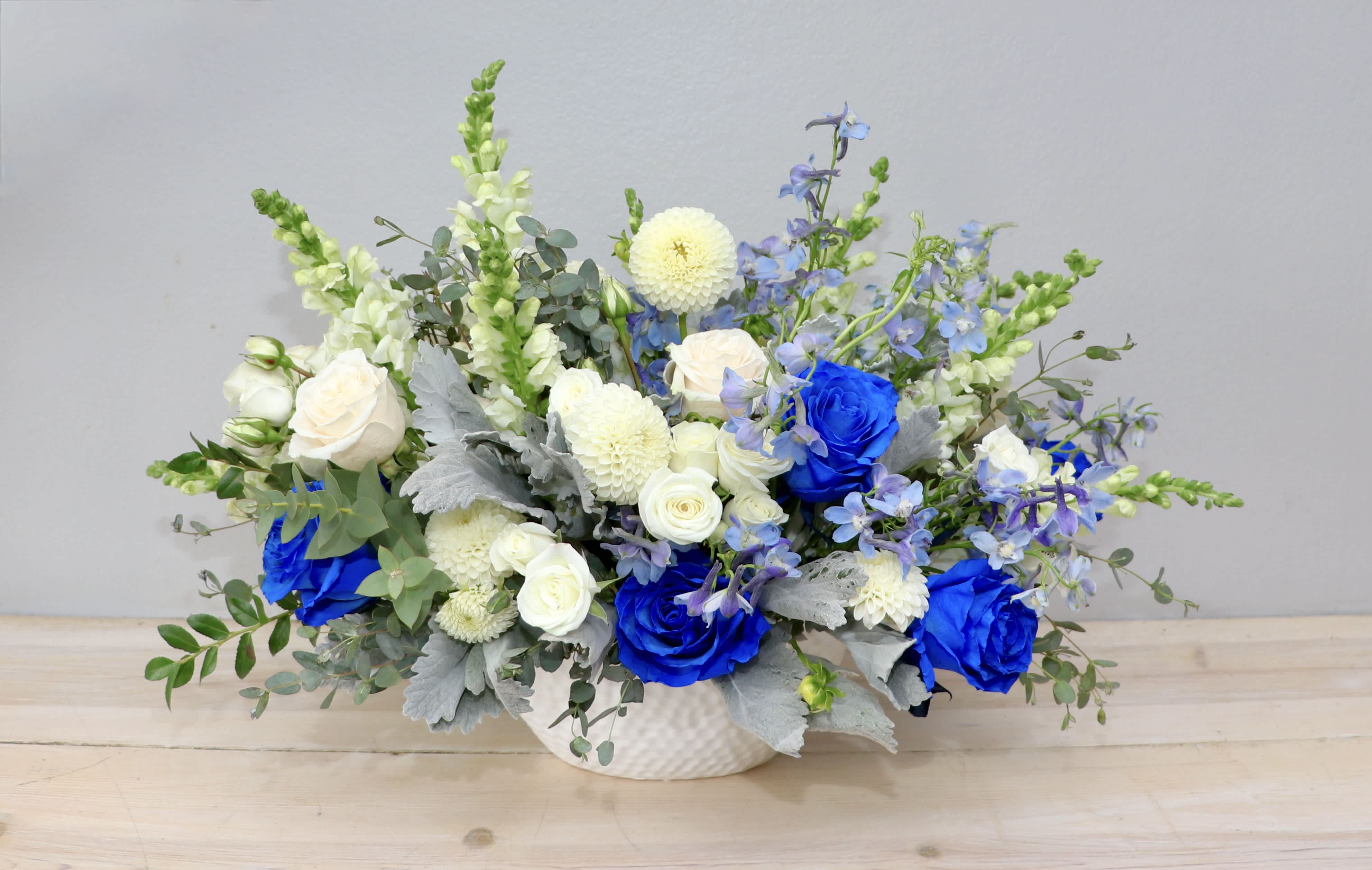 Blue and white floral arrangement in a white vase