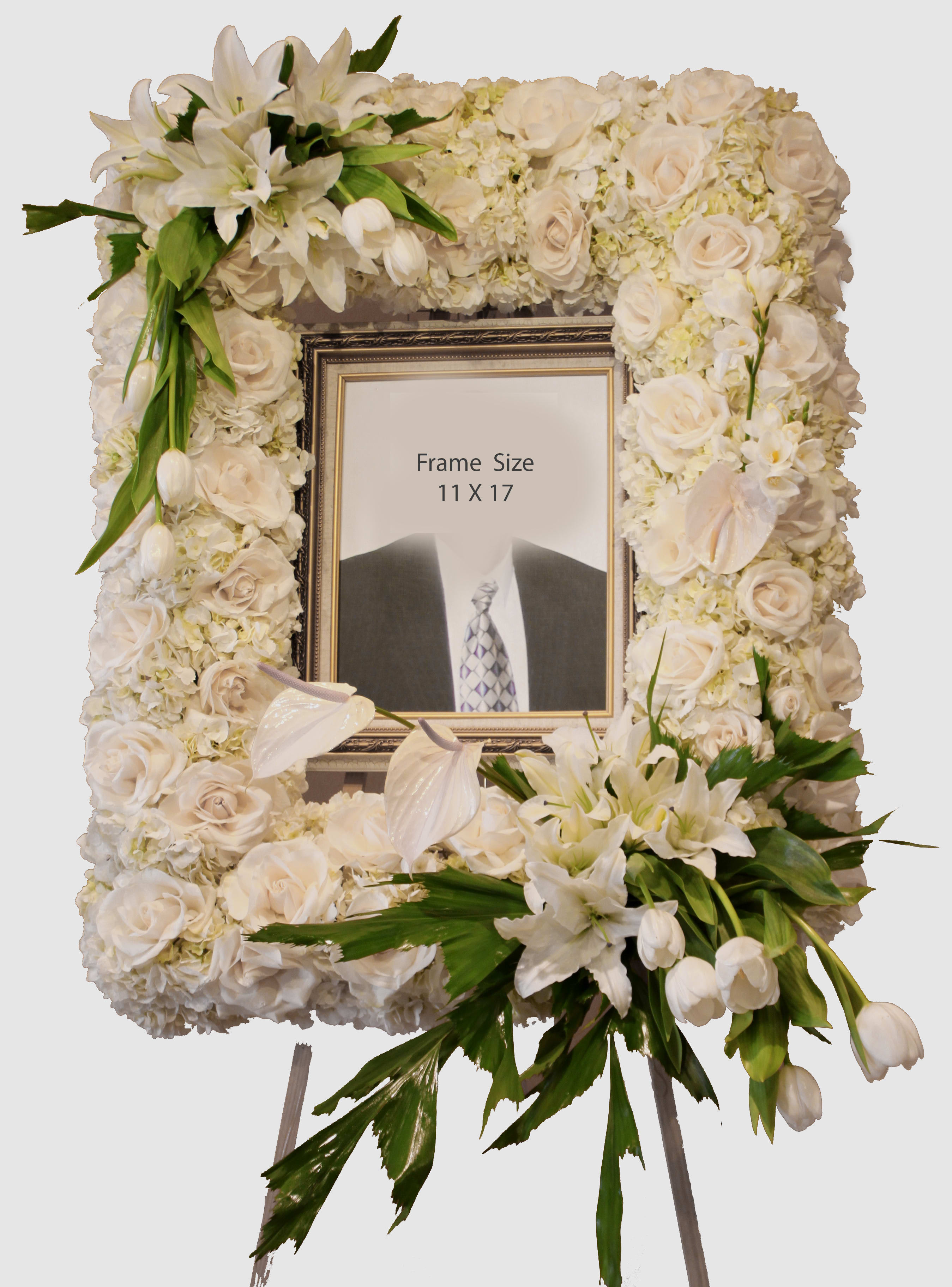 Standing white floral photo frame with lilies, roses, and tulips around an 11x17 picture frame on an easel