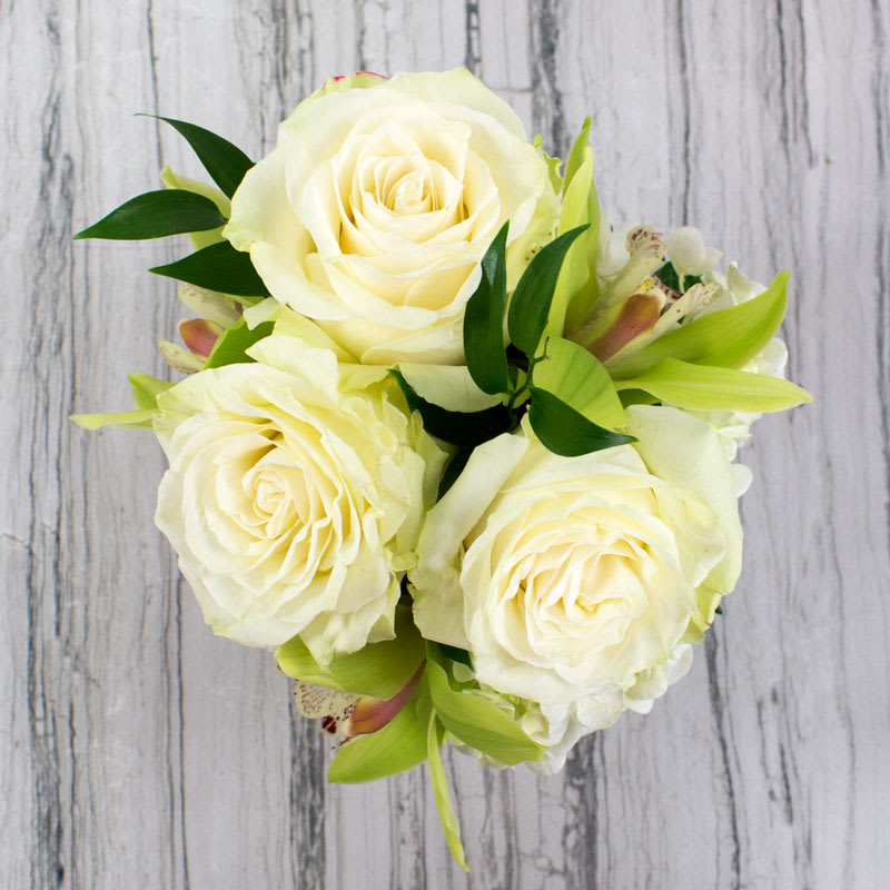Dainty Duet - Sometimes something small and sweet is all you need to say a million words for a million reasons. We love this little duo showing off a petite selection of White Roses and Pistachio Green Cymbidium Orchids in a clear glass vase. Perfect for a desk or tableside.