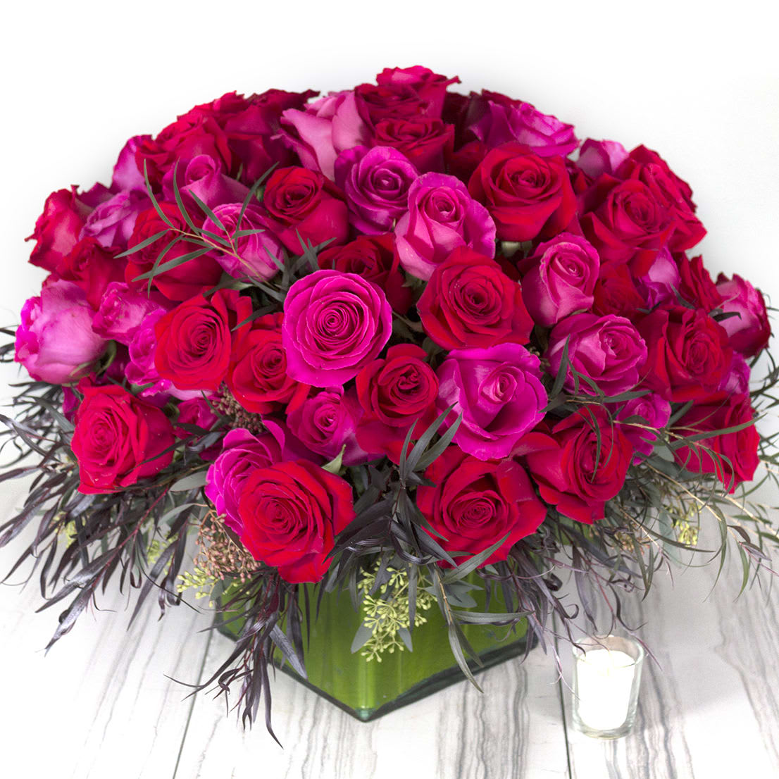 Wild Strawberries - Love, Love, Love! A cluster 100 gorgeous red and pink Roses are encircled by a bed of feathery and airy mix of greens to create this eye-catching and dramatic statement of color, beauty, and love.  Standard: 100 Red &amp; Pink Roses  Deluxe: 150 Red &amp; Pink Roses 