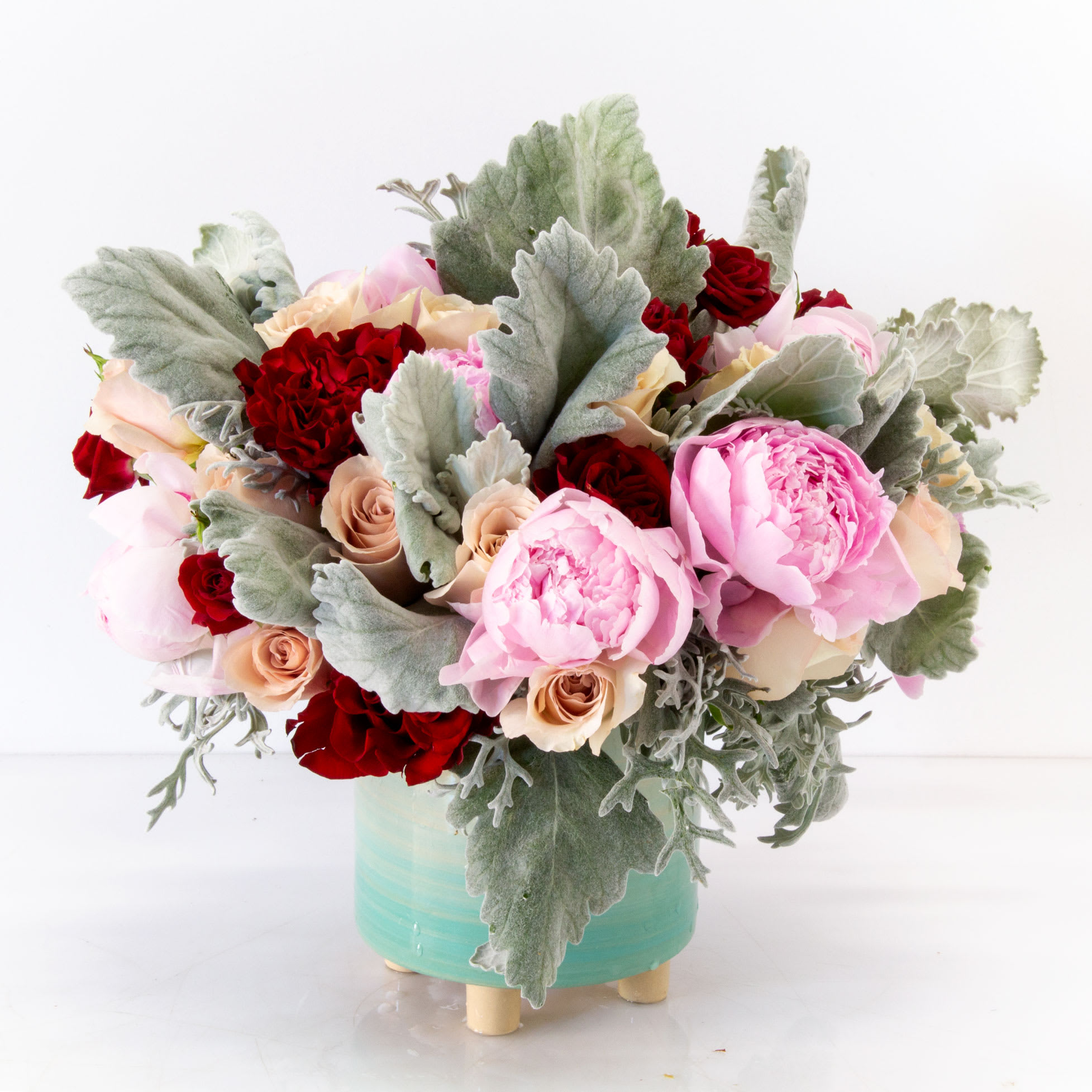 Pink and Red Paradise - A vibrant and eye catching design that will light up any space with 1 Dozen of pink Peonies, accented with sand color and burgundy Heart Roses, create a lovely accent amongst the delicate shades of pink and approximately 18" tall and 18" wide with a beautiful ceramic container.