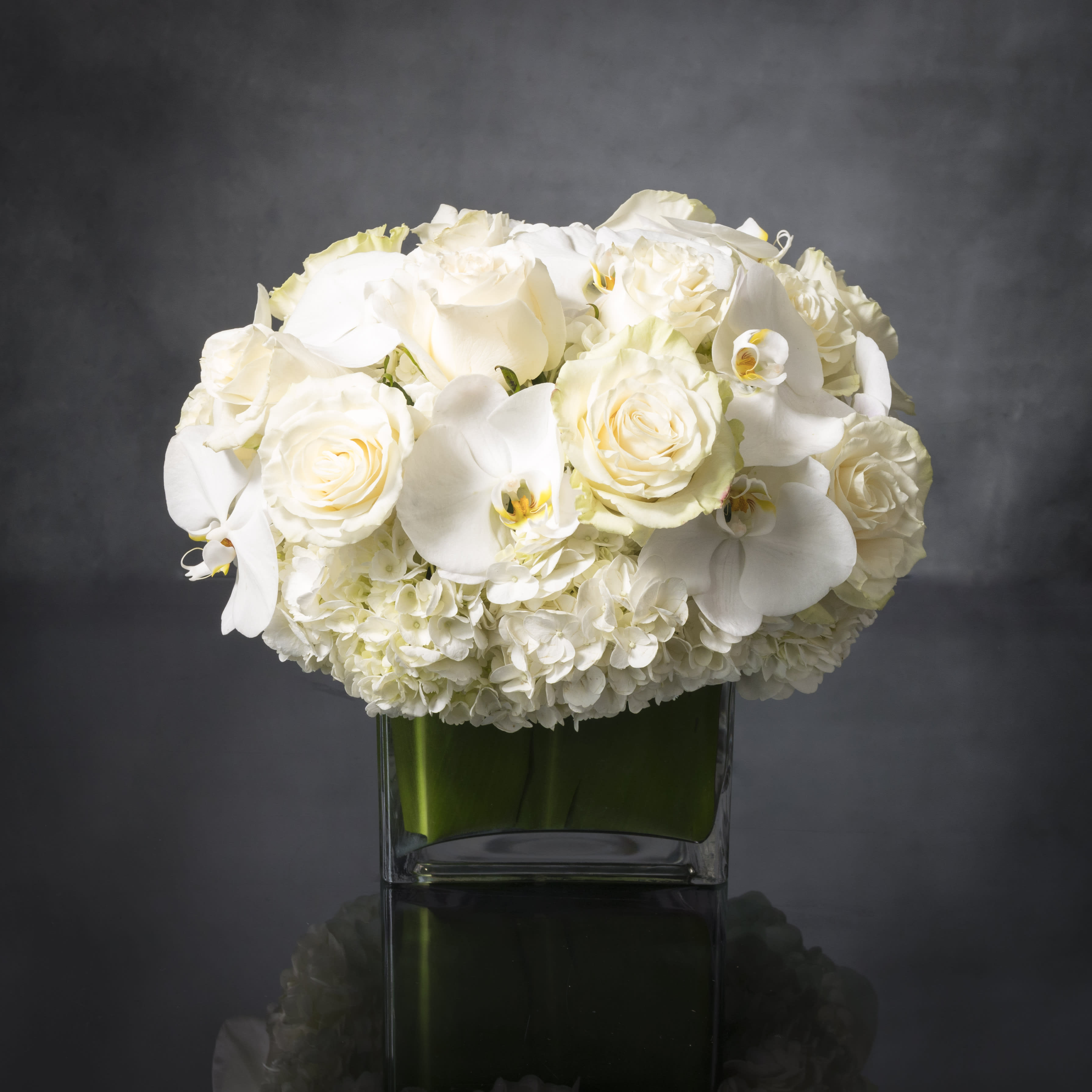 Pearl Elegance - Pearl Elegance - The arrangement includes lovely locally grown all white Roses, Hydrangeas and seasonal Orchids. It really is quite an elegant design and it makes a wonderful gift idea for any occasion.  As shown - Deluxe 
