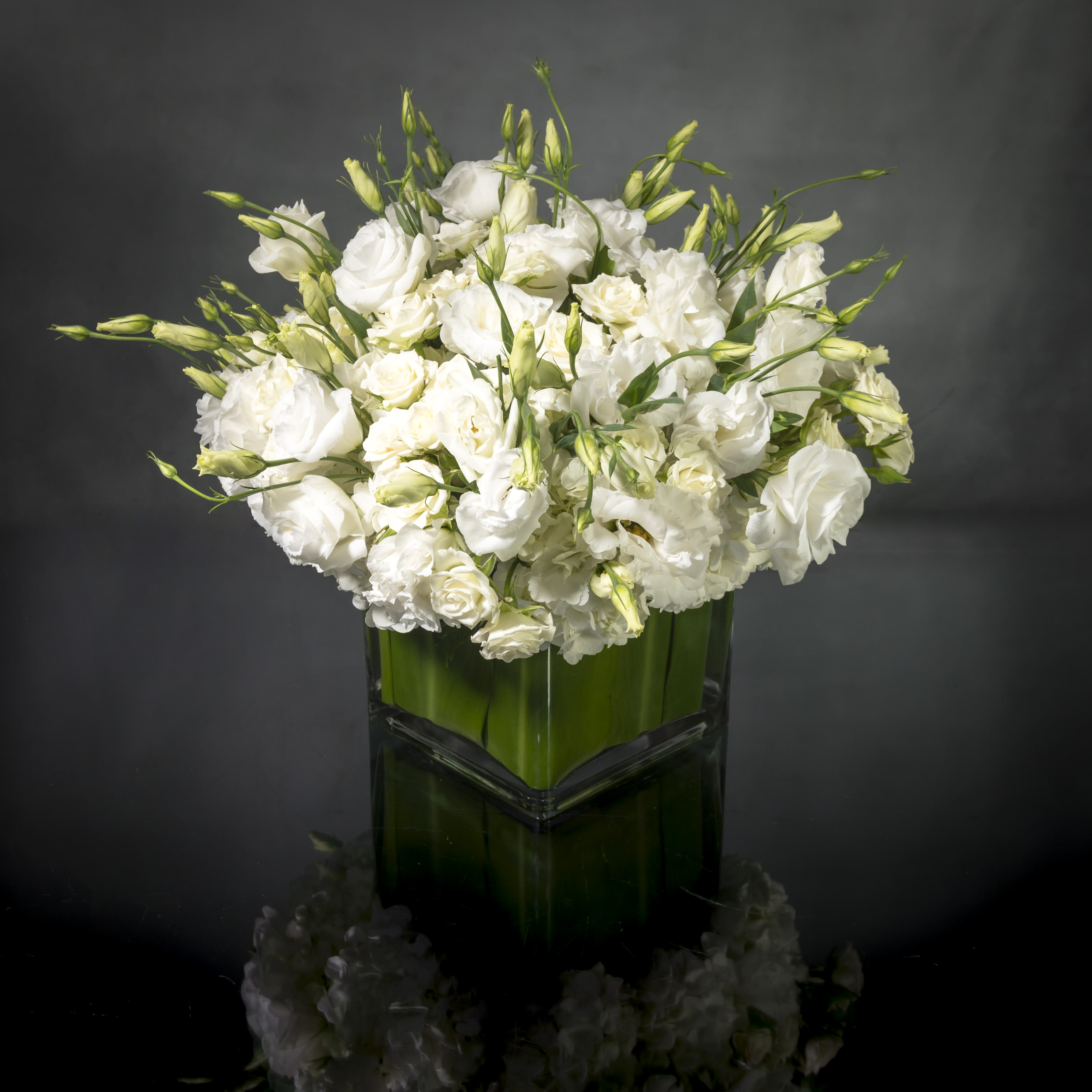 Designer's Choice - Isle of White - This arrangement is made with a designer's choice array of seasonal white flowers, ing Roses, Hydrangeas, Orchids, Tulips and or Peonies. These beautiful white flowers are an excellent choice for weddings, funerals and other major life events.   