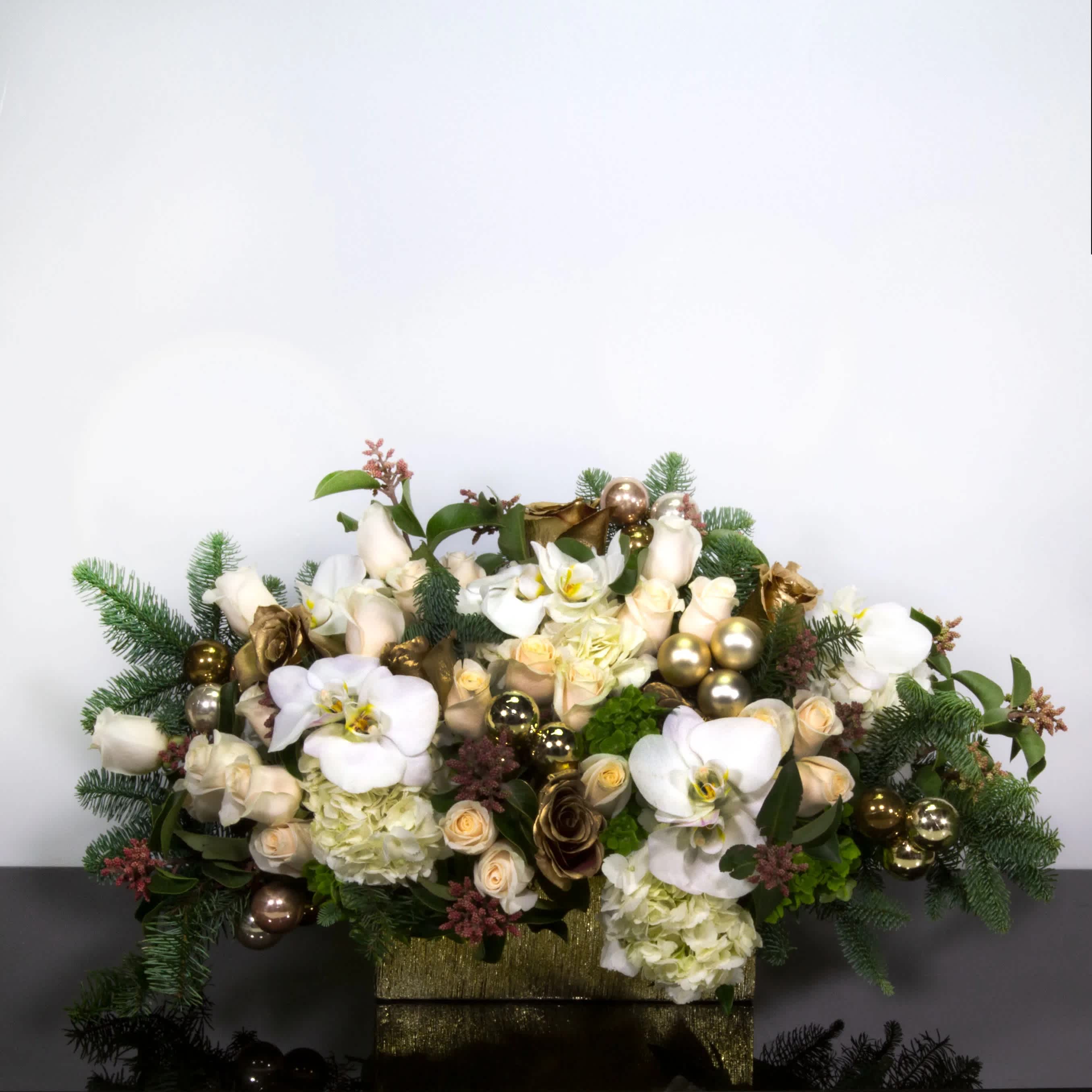 White orchids and cream roses arranged in a gold box with ornaments