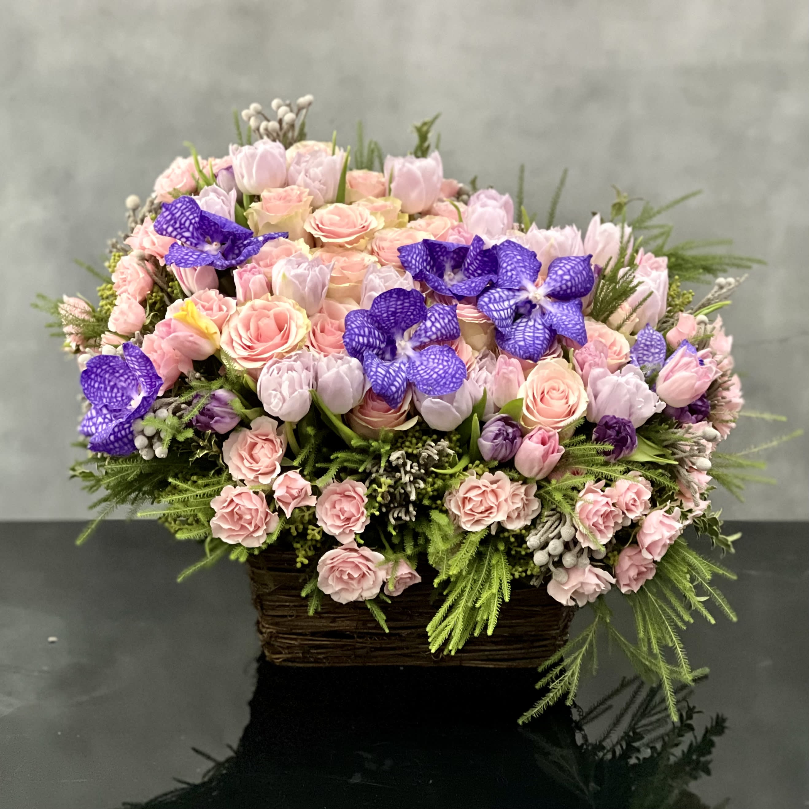 Purple Divine - A base filled with various shades of pinks and purples. This piece will add a divine sense of sophistication to any room. In this arrangement we have Orchids, Tulips and Roses to create a feeling of worldliness that is lovely. 